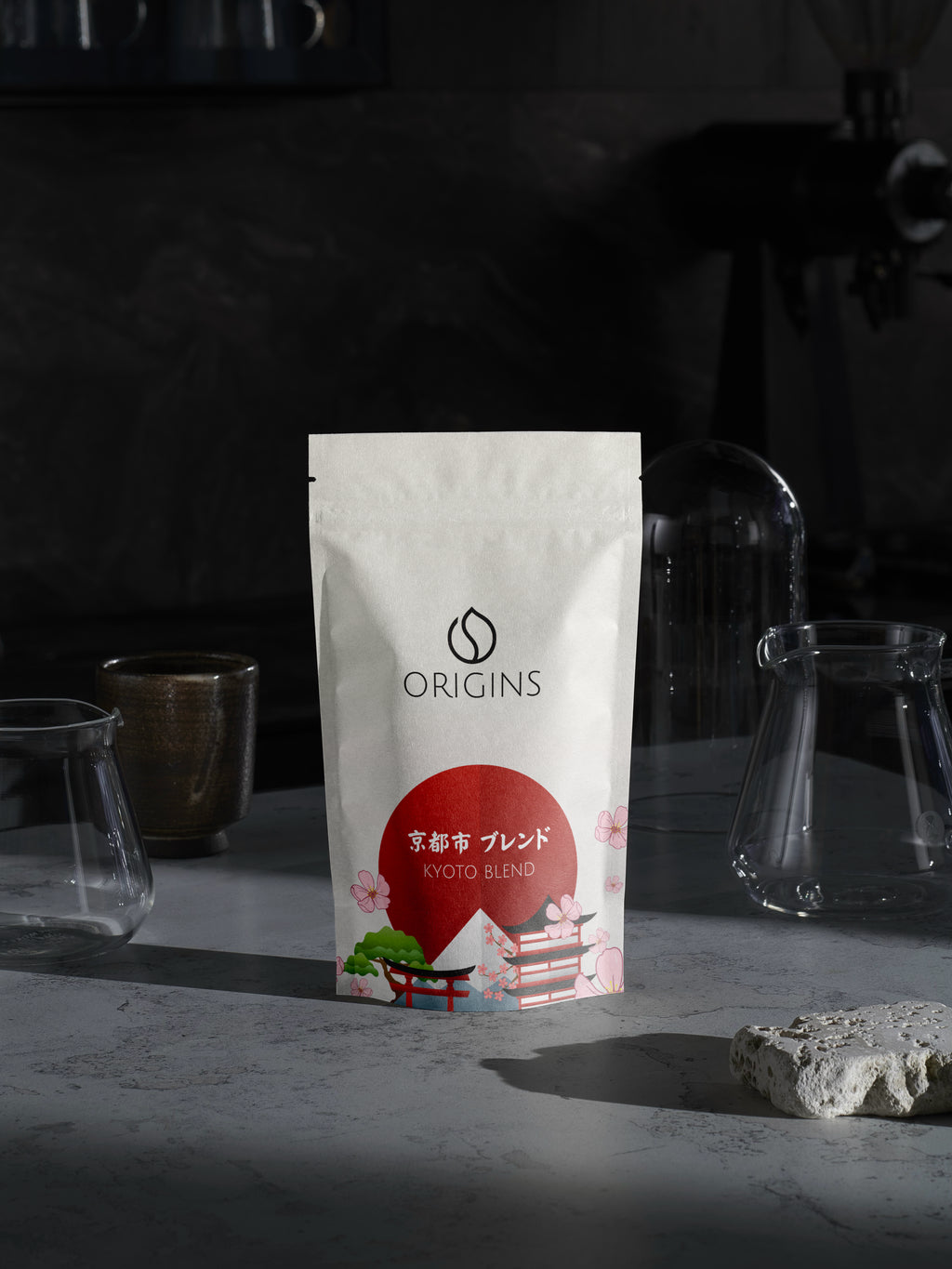 Origins coffee package on a dark background with glassware