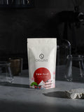 Origins coffee package on a dark background with glassware