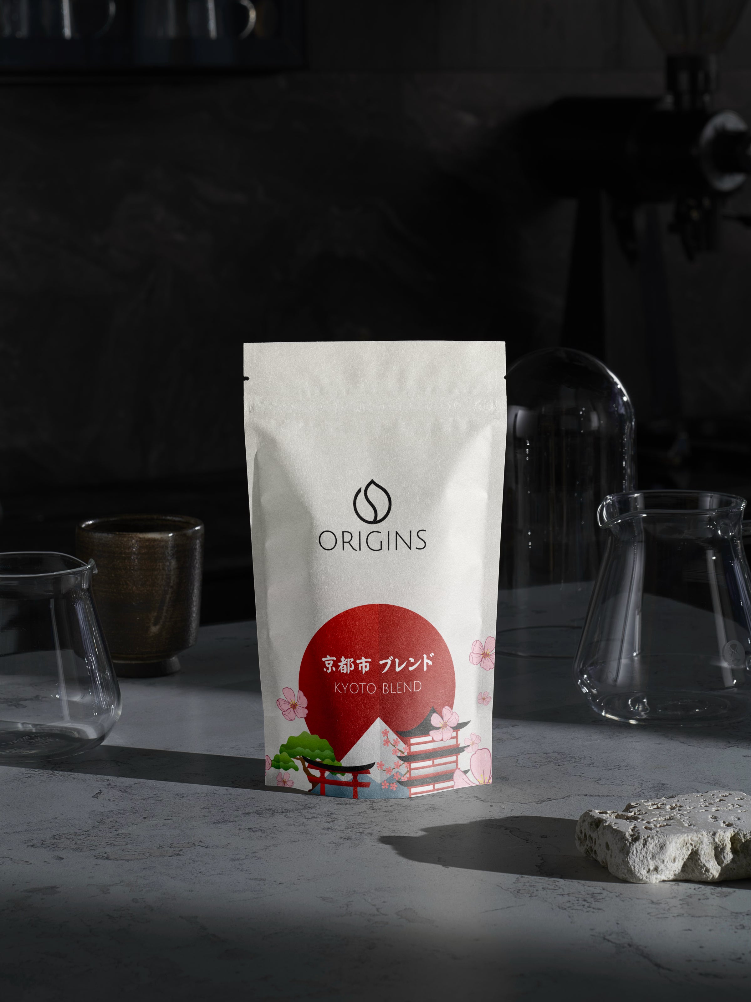 Origins coffee package on a dark background with glassware